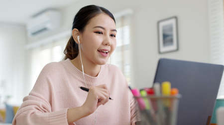 Young attractive business asian woman talking about sale report in video call conference on notebook computer online meeting in working from home, Working remotely and Social isolation concept.の写真素材
