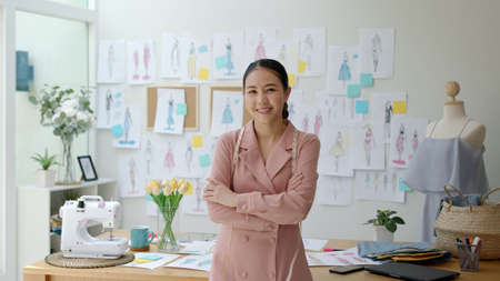 Young asia people female arm cross relax smile happy look camera work on desk at textile home office modern studio in finance loan fund for sme job digital social e-commerce sell dress online store.の写真素材