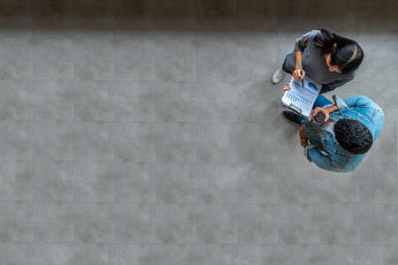 Top view of young asian business team standing, talking and reporting with annual report document in...