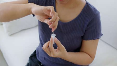 Close-up face of young adult asia woman people use auto PCR cotton self cure kit from hospital...