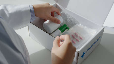 Close-up hand asia woman chemist help pack covid free first aid self recover care on desk give for...