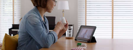 Asia sick people or happy adult woman sit at home use video call remote chat on online health care clinic app in covid self cure isolate recover drug pill teaching exam by VoIP help service screen.の写真素材