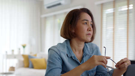 Asia adult upset sad people or pensive SME owner latin lady sit at home brownout work on desk laptop...