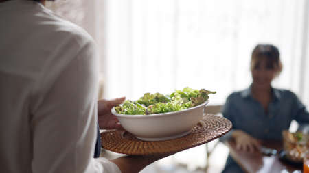 Adult SME owner work at busy small cafe bar pub on cozy day carry plate tray for group asia people...
