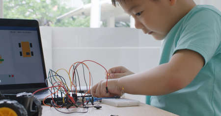 Asia home school young small kid happy smile self study online lesson excited make AI circuit toy....