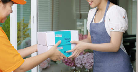 Asia people SME owner carrying parcel carton box on hand send product on site picking up at home...