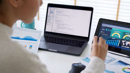 Back rear view of young asian woman, freelance data scientist work remotely at home coding...