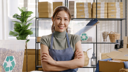 Go green use eco friendly packaging box in net zero waste store asian seller retail home office shop. Small SME owner young adult asia Gen Z people happy relax smile pride arm cross looking at camera.の写真素材