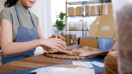 Eco vendor go green packaging parcel carton box in net zero waste store asian seller retail shop. Earth care day small SME owner asia people wrap reuse brown paper pack gift reduce plastic free order.の写真素材