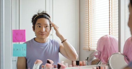 Gay queer man non-binary beauty blogger makeup artist at home cross dressing up apply face skin care eye make up brush. Real asia LGBT young guy adult people happy relax smile looking at mirror pride.の写真素材