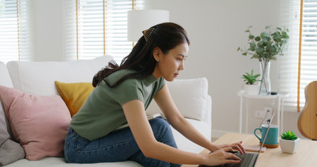 Reskill upskill for young adult talent workforce remote work at home hybrid workplace. Asia woman happy smile sit at sofa couch learn online study MBA video call share plan idea write note on tablet.の写真素材