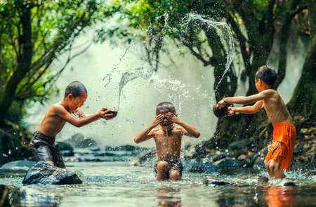 Childs splashing in the riverの写真素材