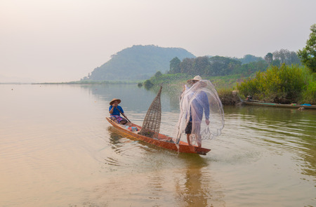 Fishermen in action when fishing in the mekong river , Thailand.の写真素材