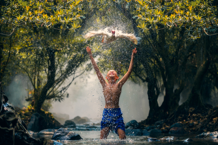 children playing catch duck in riverの写真素材