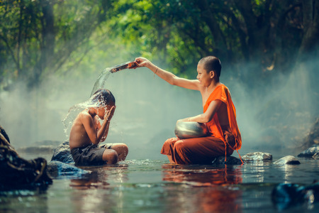 Novice and Boy playing at waterfallの写真素材