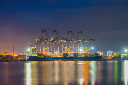 Industrial port with containers cargo ship in the trade port, shipping, transportation, logistic import export at sunset, twilight time.の写真素材