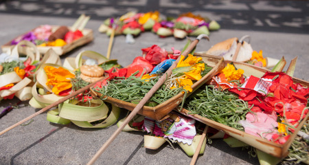 Traditional balinese offerings to gods  with flowers and aromatic sticks at Bali,Indonesia.