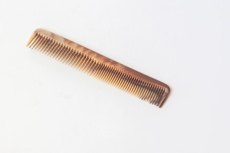 Brown plastic comb on white.
