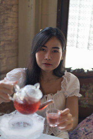 Portrait of a young smiling woman having a dessert in a cafeの写真素材