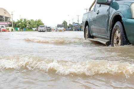 Cars driving on a flooded road, The broken car is parked in a flooded road.