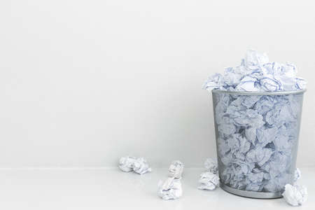 Crumpled paper throw into the gray trash with sliding view. Tossing paper scrap away bin. No idea.の写真素材