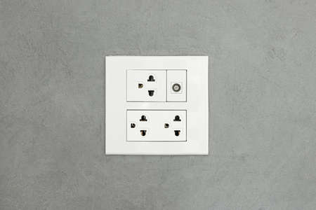 Electrical outlet on wall loft style,Power plug on white concrete wall, Energy socket.