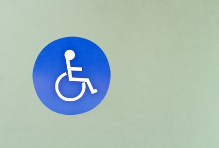 Blue wheel chair sign for  handicapped person in front of restroom's doorの写真素材