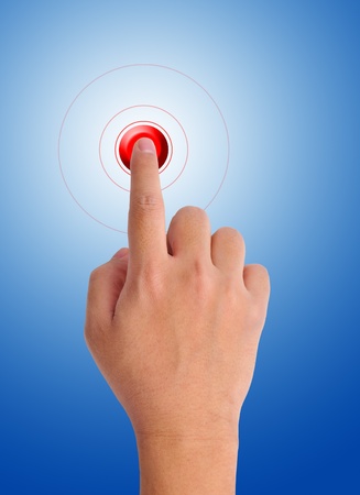 hand pushing a red button on a blue backgroundの写真素材