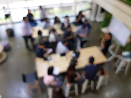 Blurred defocus top view shot of casual business meeting with one person present with the screen. Conference, training or brainstrom concept. Workspace or modern workplace background.の写真素材