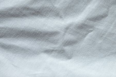 Wrinkled White fabric close up shot of good quality Cotton and polyester shirt. formal wear for office worker . Background texture concept with copy space for text.の写真素材