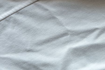 Wrinkled White fabric close up shot of good quality Cotton and polyester shirt. formal wear for office worker . Background texture concept with copy space for text.の写真素材