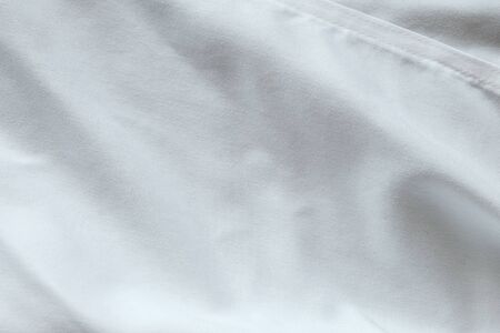 Wrinkled White fabric close up shot of good quality Cotton and polyester shirt. formal wear for...