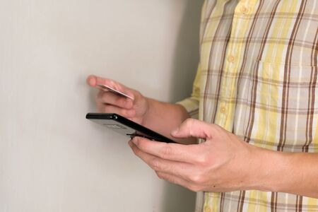 Men hand holding credit card and type payment information on mobile device for order online shopping. Internet technology and Digital market place E-Commerce lifestyle concept, Purchase transaction.の写真素材