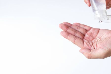 Selective focus of Asian men hand using Alcohol gel, hand sanitizer for personal hygiene on white background to protect, prevent from virus and illness during Corona virus outbreak or Covid 2019.の写真素材
