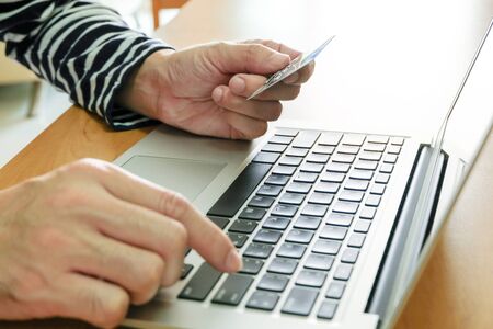 Men hand holding credit card and type payment information on keyboard for order online shopping....