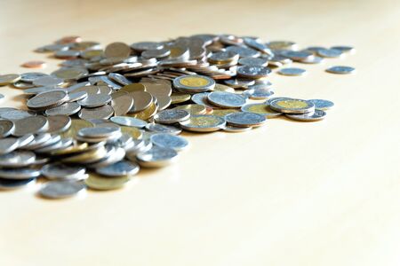 Selective focus, Different type on Thai Baht coin on put on light brown wooden table with shade of light. Money currency, financial object with copy space for text. Ideal for saving or earning conceptの写真素材