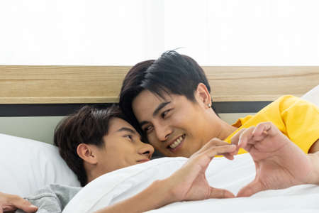 Selective focus at face. Close up shot of good looking Asian gay homosexual couple hug and smile...