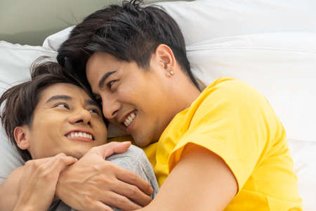 Asian gay homosexual couple hug and embracing on the bed.  Gender equality and right concept, playful and romantic moment.の写真素材