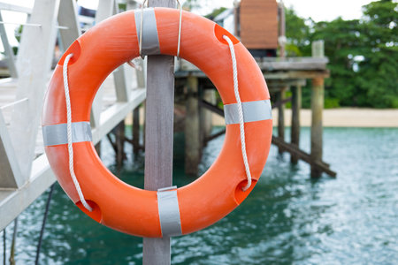 Life Buoy attached to a Wooden Paneled at beach front area to use in case of emergency. Standard...