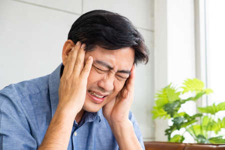 Close up shot of Asian male  senior using hands to touch his head when suffering and pain from...