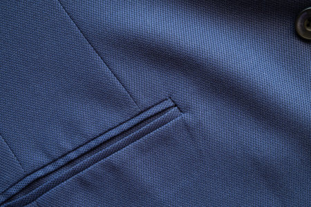 High resolution with details and quality shot of formal dark blue wool suit fabric texture. with front pocket decoration under light and shadow ambient. Ideal for background or wallpaper.の写真素材