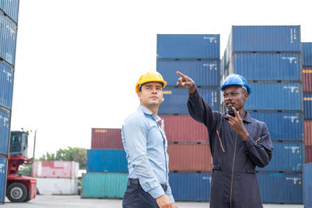 Selective focus at African black worker while talk and having discussion with supervisor and inspect the condition of all containers shipment, People and worker in freight deliver, import and export.の写真素材