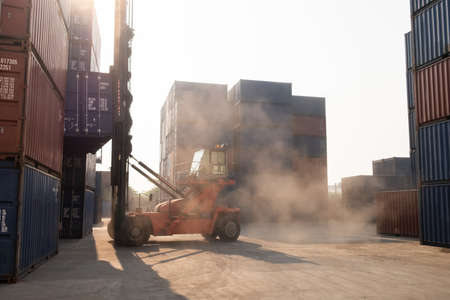 Motion shot of industrial container loading site shot with a pile of many container while fork lift...