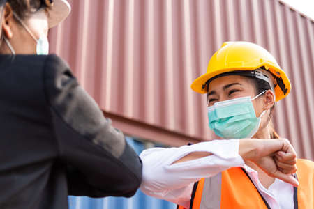 Selective focus at face of female industrial warehouse container worker wearing safety helmet and...