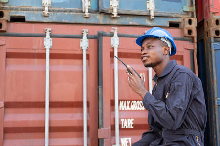 Selective focus at face of Black African logistic worker wearing safety equipment, check and...