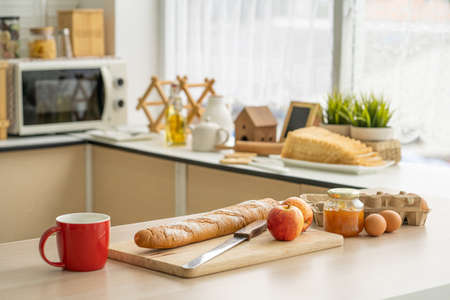 Selective focus at the fresh baked bakery bread put on the kitchen desk with bottle of powder ingredient with blurred background of kitchen equipment ready to prepare food meal for breakfast.の写真素材