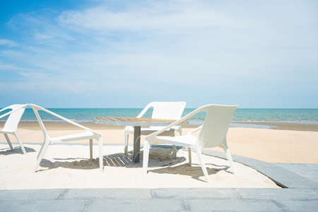 à¸ºBeach bed chair decoration outdoor furniture wooden patio at sea beach front. With green coconut tree and blue sky nature terrace background.の写真素材
