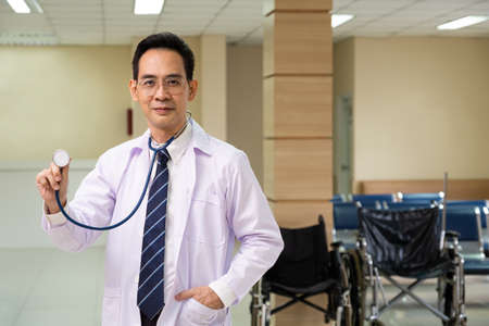 Portrait shot of doctor wearing white medical gown and standing with confident insider of the hospital. Healthcare expertise, professional service.の写真素材