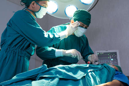 Selective focus at face of male nurse assistance. While help to support the doctor who doing...