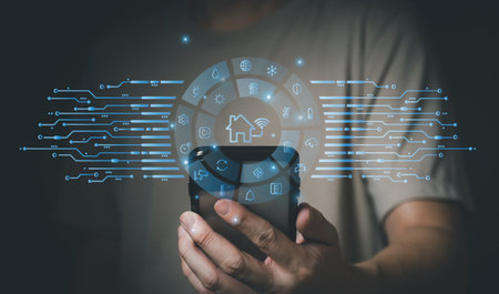 People hand using smartphone or computer laptop to access smart home application from internet wireless connection to control and monitoring smart device inside of the house. Internet of things.の写真素材